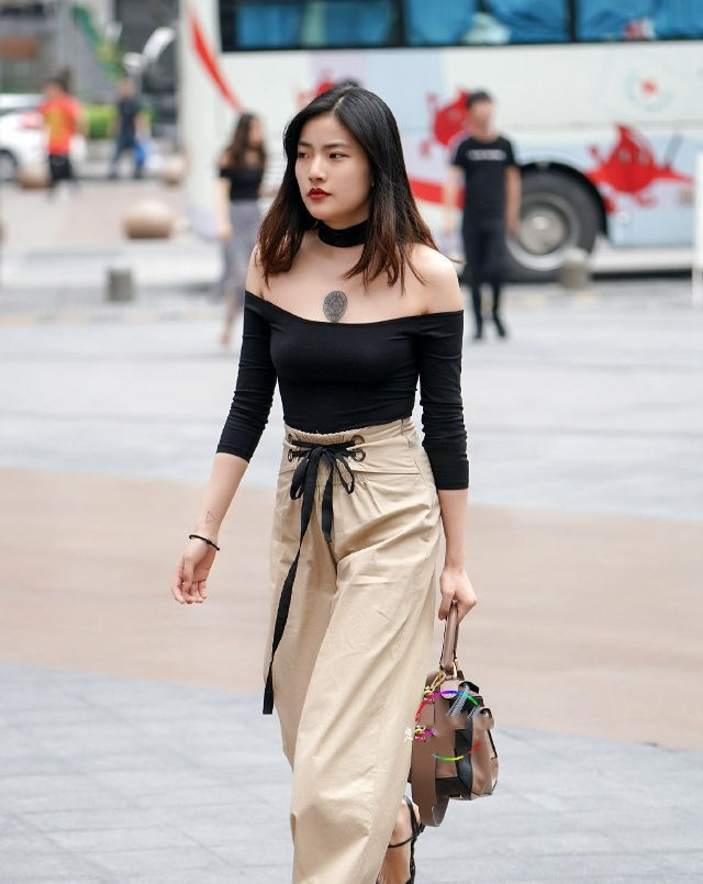 黑色|路人街拍,美女穿着一件黑色的刺绣印花大衣,休闲感十足