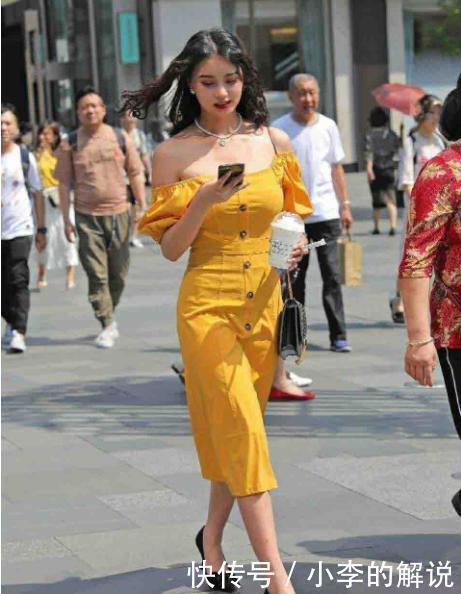 米黄色连衣裙搭配黑色包包，色彩鲜艳，高挑又迷人