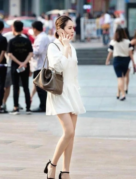 街拍:身材高挑的小姐姐,穿牛仔短裤,秀出大长腿和小蛮腰