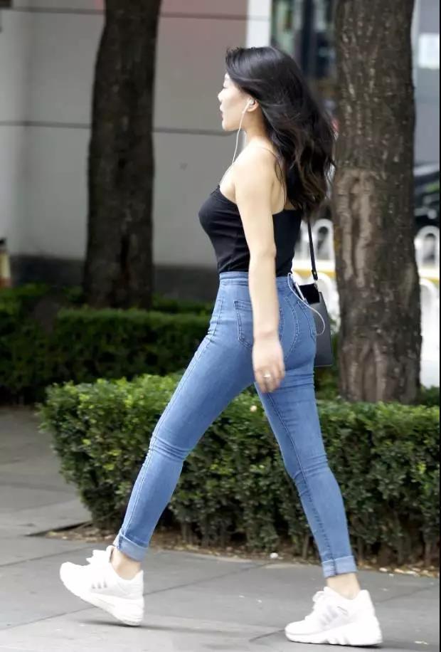 吊带|街拍黑色吊带背心搭紧身牛仔裤的性感姑娘,大方洒脱的气质