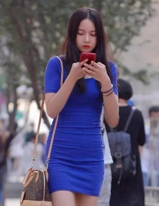 街拍:小姐姐身穿红色无袖上衣,搭配白色的长裤,造型很时尚