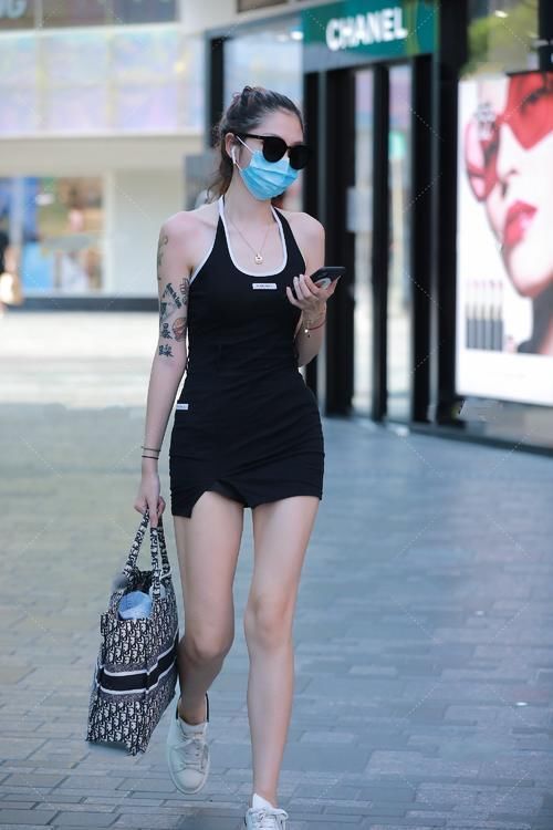  小姐姐爱穿黑色挂脖式吊带修身裙，她有点迷人，时尚而优雅