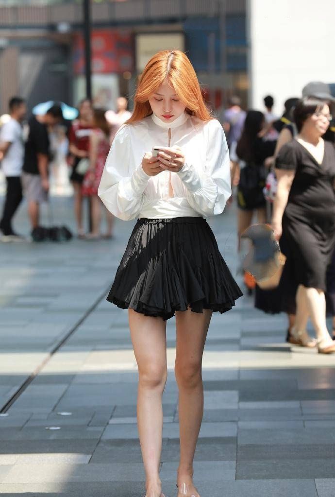 街拍:美女身穿黄色毛衣搭配小皮裙,笑容甜美可爱,非常时髦