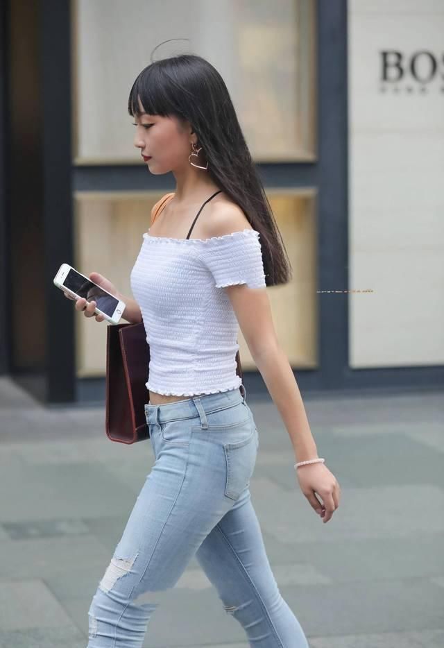 街拍|街拍美女破洞紧身牛仔裤搭配白色漏肩针织衫,很素雅的小姐姐