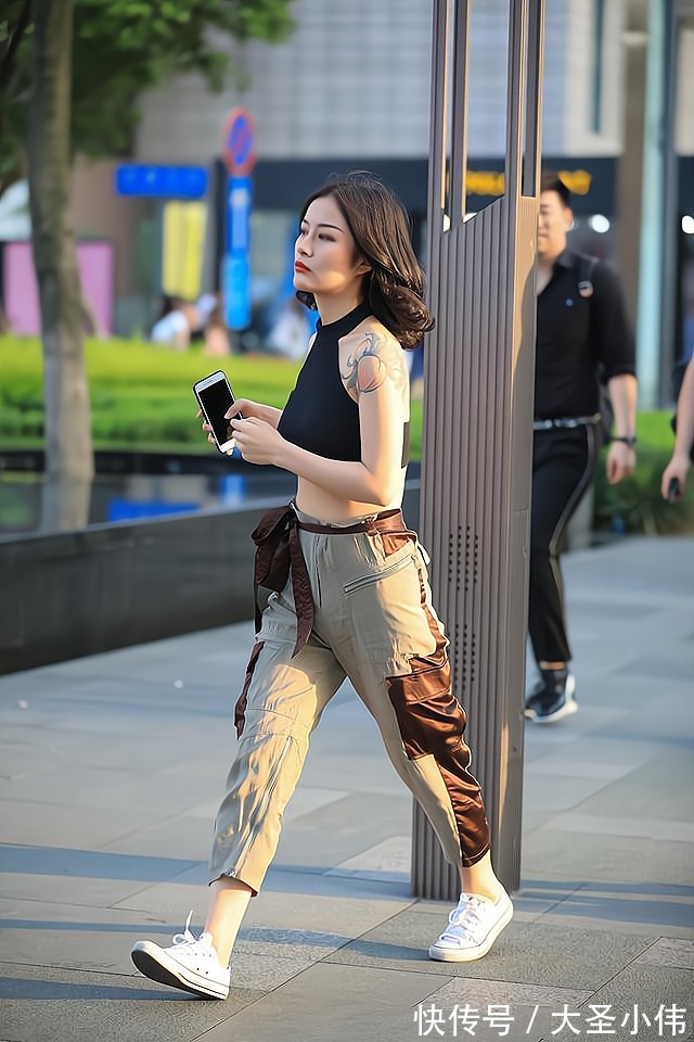 棕色|美女街拍:黑色挂脖上衣搭配拼色工装裤,搭配布条腰带,时髦个性干净利落