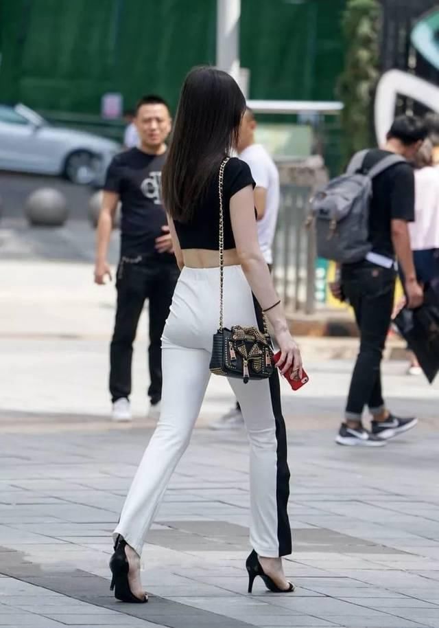 街拍牛仔短裤搭配黑色吊带背心,精致装扮为气质加分