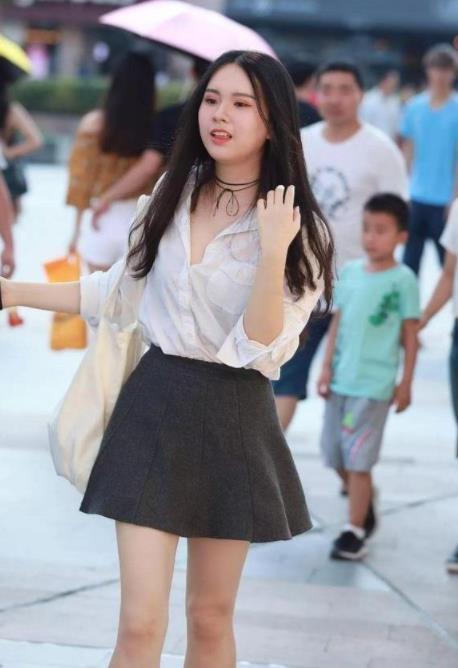 灰色|街拍长发小姐姐,身穿一件黑色的露肩上衣搭配一条灰色的半身裙,温婉可人