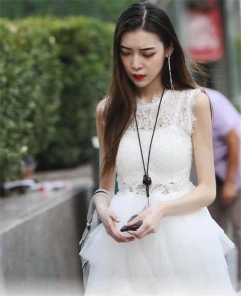 街拍：美女身穿裸色连衣裙，肌肤如玉，身姿曼妙