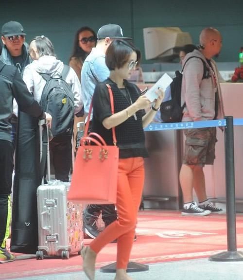 马伊琍穿黑色上衣，搭橙红色的休闲裤，打扮时髦且拉风！