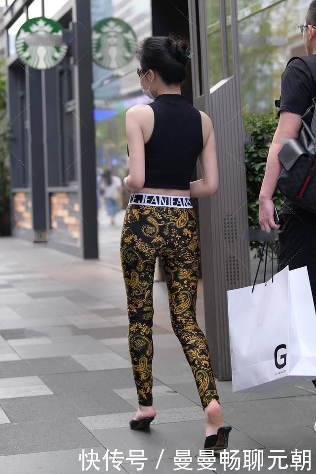 阿姨黑色半高领上衣搭配花纹修身裤,设计精美,尽显时髦气息