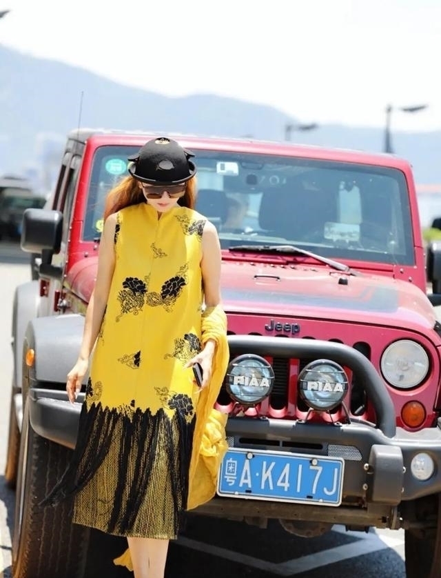 机场|60多岁的杨丽萍活出了自信,穿红色民族裙走机场,推竹筐好洋气