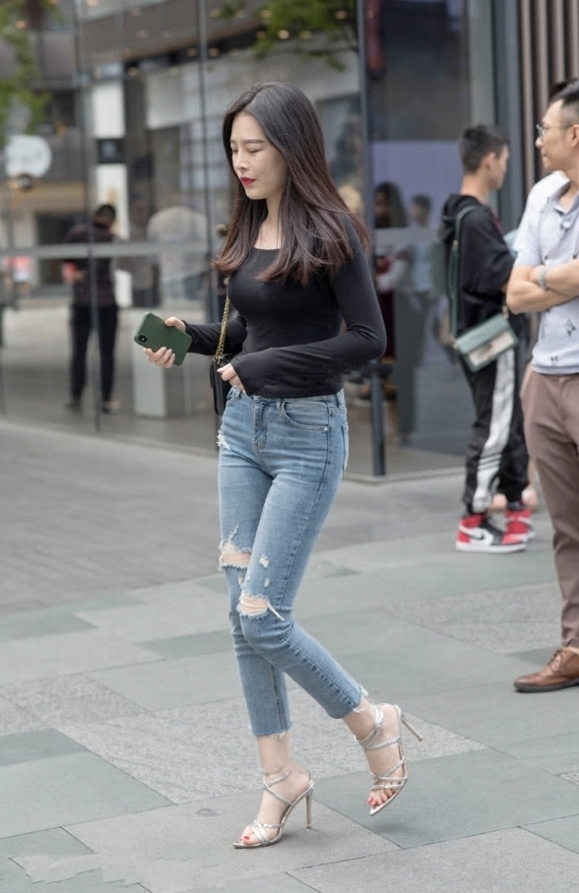 路人街拍，美女搭配黑色的修身打底衫，更显自信优雅