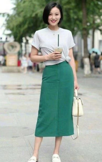 街拍:花枝招展的小姐姐,一件时尚的上衣配短裙,显得妩媚又时尚