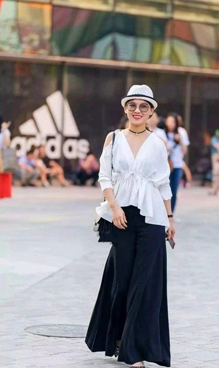 长裤|街拍:身材高挑的美女,身穿吊带配牛仔长裤,时尚优雅美丽大方