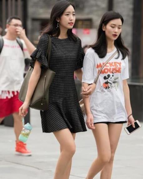 街拍喝奶茶的小姐姐,黑色吊带搭配黑色短裤,大长腿很吸睛