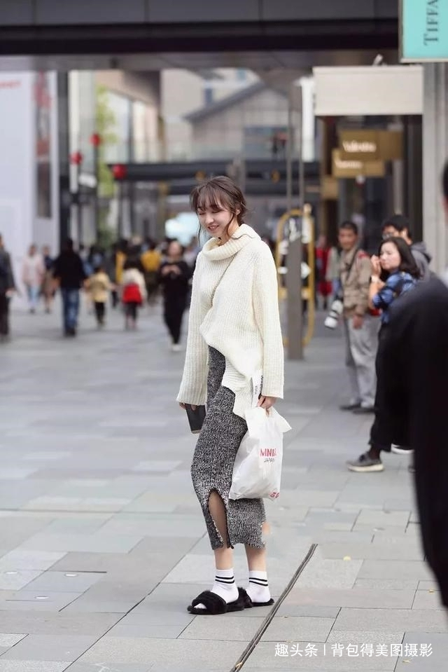 白色|路人街拍,美女选择一款米白色的露肩连衣裙,时尚又有女神范