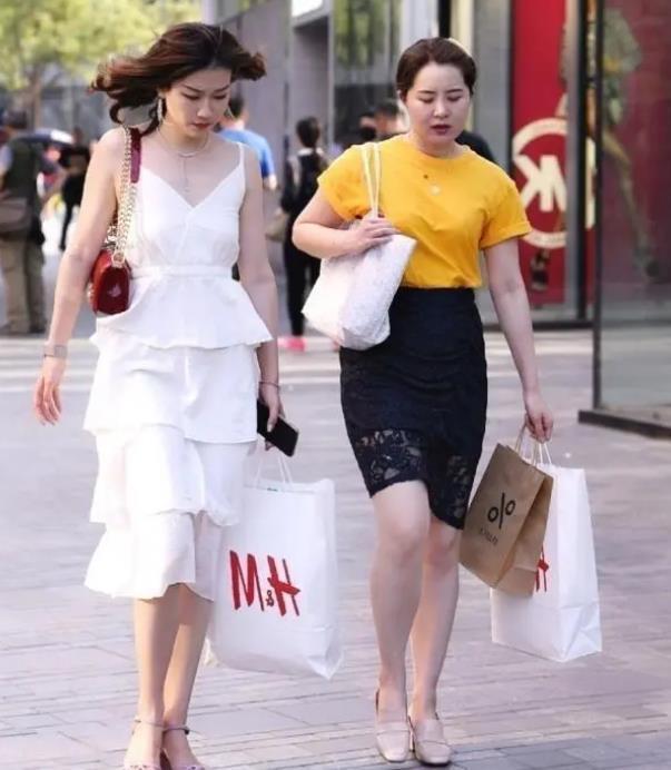 街拍:美女戴一副时髦的太阳镜,黑色的连衣裙帅气大方