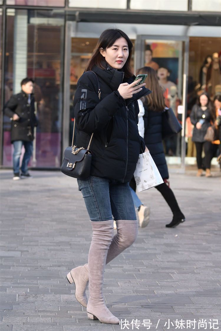 街拍 街拍:美女搭配黑色羽绒服,选择牛仔裤和过膝靴,别样的时尚味道