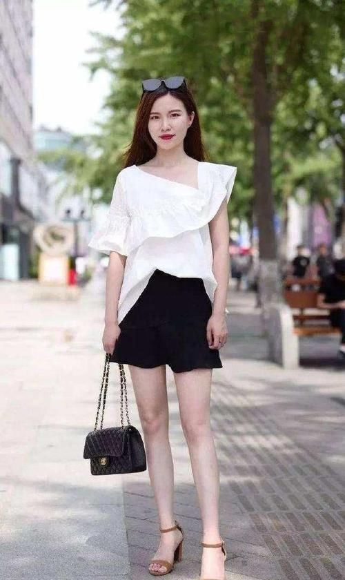 身穿|街拍小姐姐身穿喇叭一字肩上衣搭配浅蓝色牛仔热裤,美丽动人