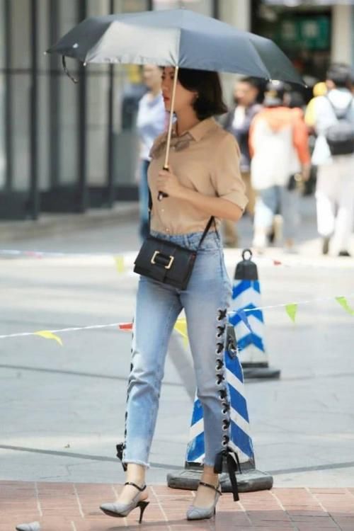 路人街拍，美女穿黑白色竖条格的小衫，轻松穿出魅力的女人味