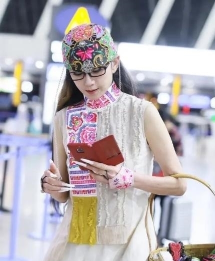 机场|60多岁的杨丽萍活出了自信,穿红色民族裙走机场,推竹筐好洋气