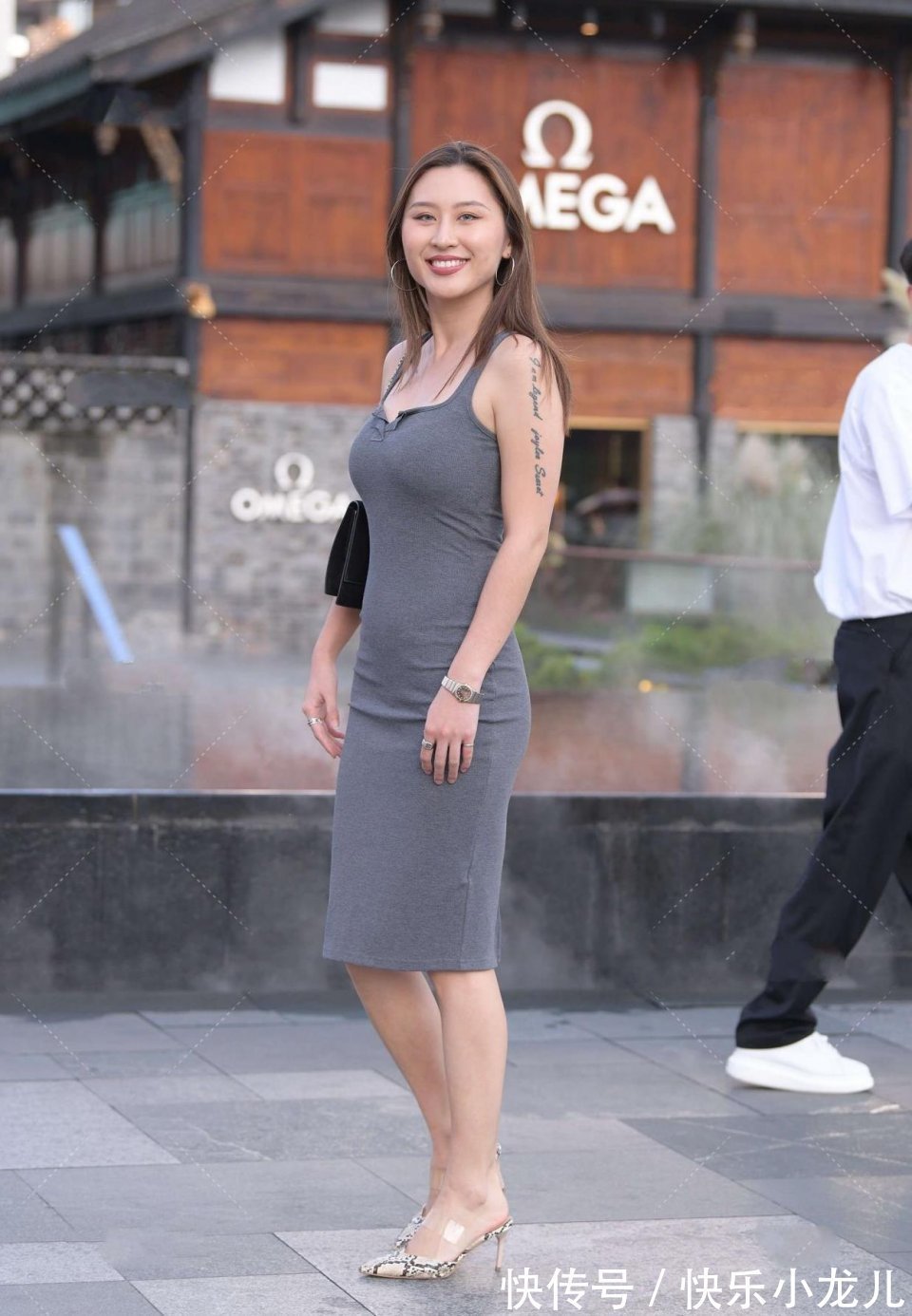 小姐姐|高挑的小姐姐身穿灰色的连衣裙,背了一款玄色的包包,搭配一双高跟鞋,很有时尚感