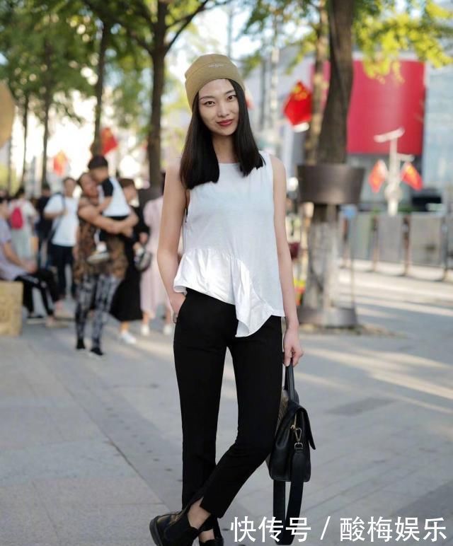 小姐姐|街拍，小姐姐白色无袖上衣搭配黑色紧身裤，身材高挑笑容甜美