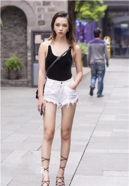 街拍:光彩照人的美女,一件蓝色吊带配白色毛边短裤,女神范十足