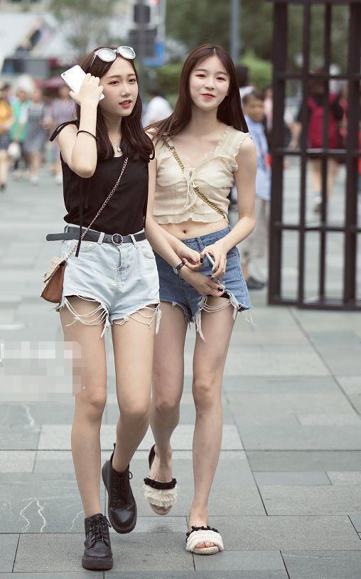 背心|街拍:专注手机的美女,背心配黑色碎花裙,凸显完美身材