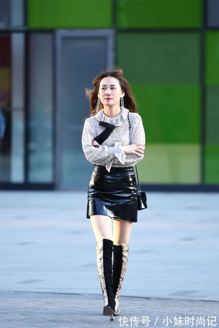 美女 街拍:美女高腰的黑色漆皮短裙,搭配拼接色的过膝靴,非常洋气!