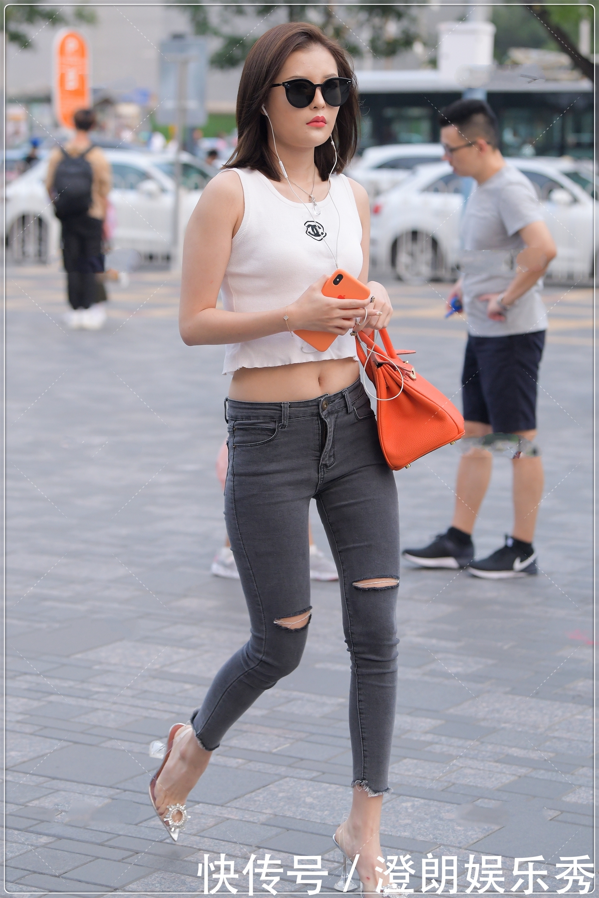街拍美女简单的白色背心,搭配露膝牛仔裤很时髦,简约时尚