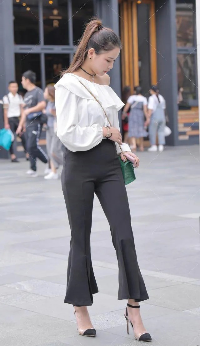 喇叭裤 皮肤白皙的美女,一件白色露肩上衣搭配黑色喇叭裤穿搭出众显贵气
