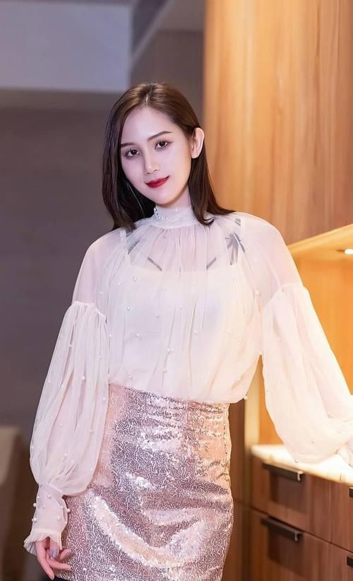 甜美|米白色的网纱上衣甜美温柔，小高领的设计衬托出精致的时尚