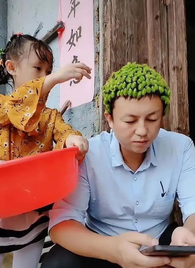 “最淡定爸爸”网络走红,被女儿打扮成“佛陀”,依旧埋头玩手机