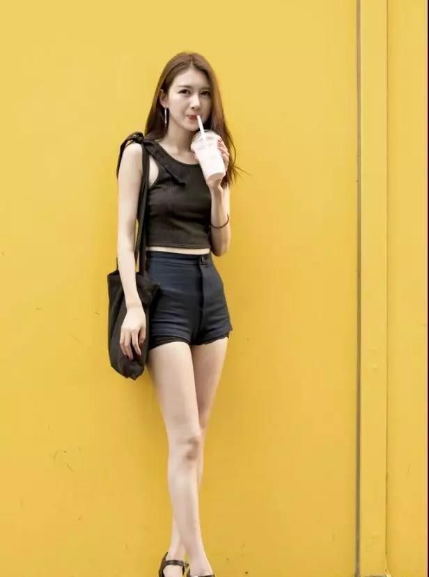 街拍喝奶茶的小姐姐,黑色吊带搭配黑色短裤,大长腿很吸睛