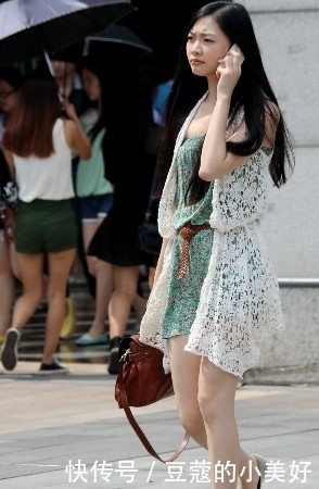 街拍:打电话的美女穿一身镂空连衣短裙,突显清秀潮流气息