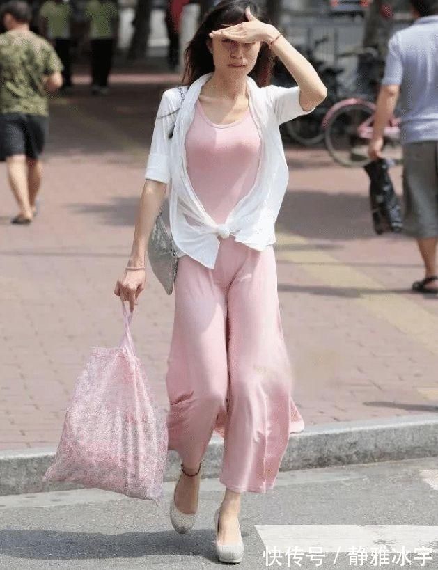 防晒衣|街拍紧身的粉色吊带连衣裙,搭配时尚白色防晒衣,优雅而性感