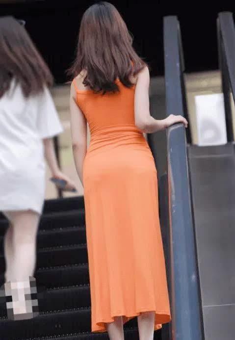 街拍小姐姐身穿橘子色连衣长裙,更显青春靓丽的气质