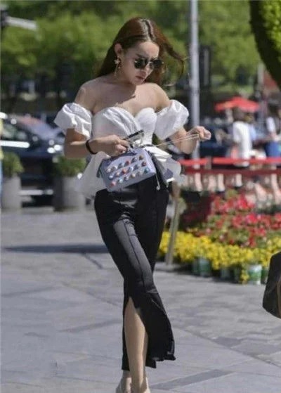 街拍:美女身穿白色抹胸上衣,身材高挑,一双大长腿吸睛无数