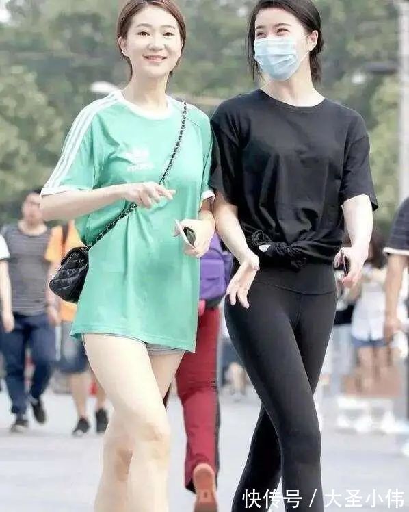 露脐短袖 美女街拍:白色露脐短袖搭配黑色打底裤,可爱显瘦,年轻女孩的必备穿搭