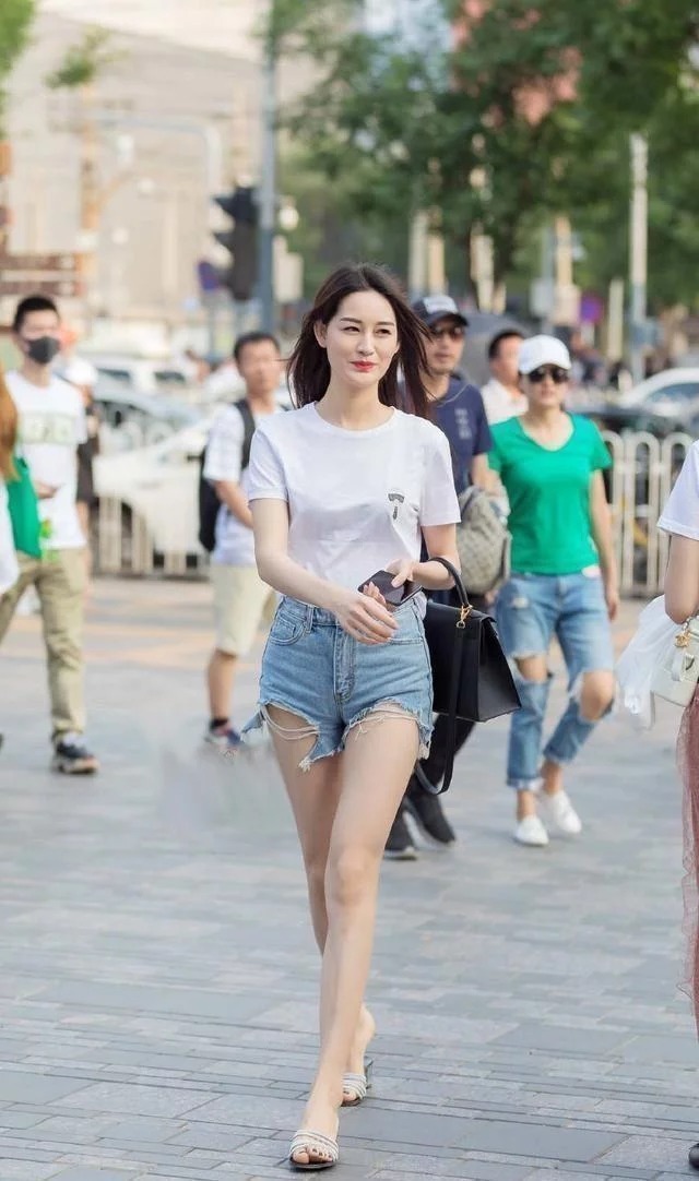 美女|秀发披肩的美女,时尚破洞牛仔裤,整体搭配显得简约干练