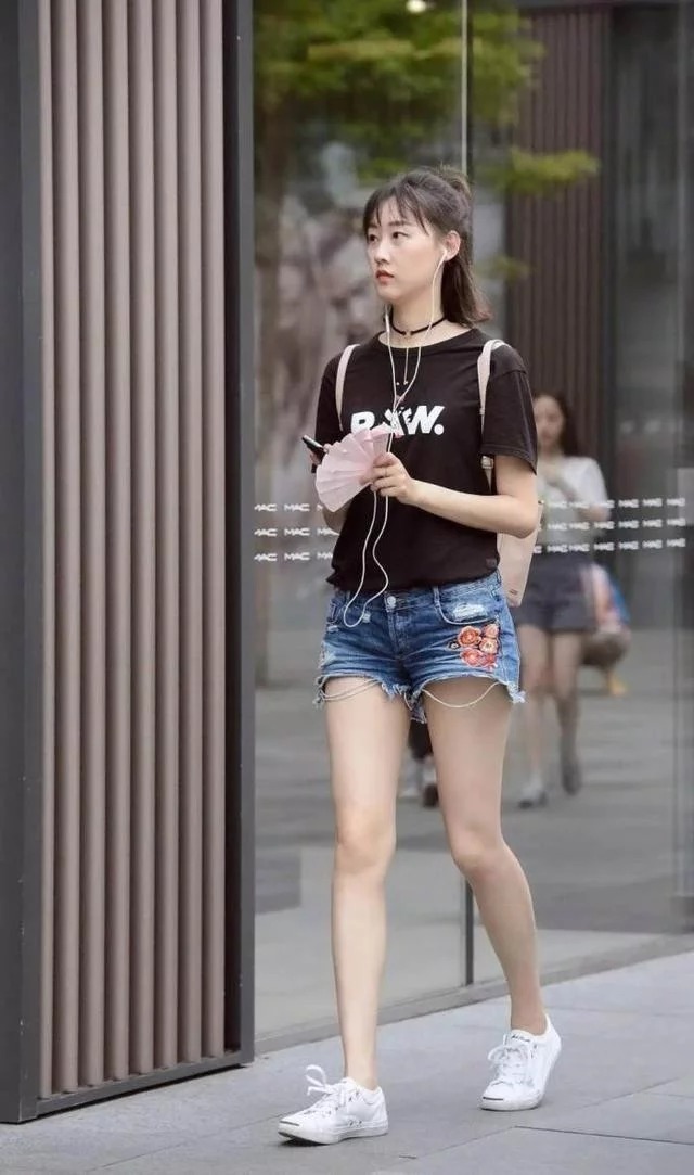 街拍:棕色卷发披肩的小美女,配戴一副黑色墨镜,显得气场十足