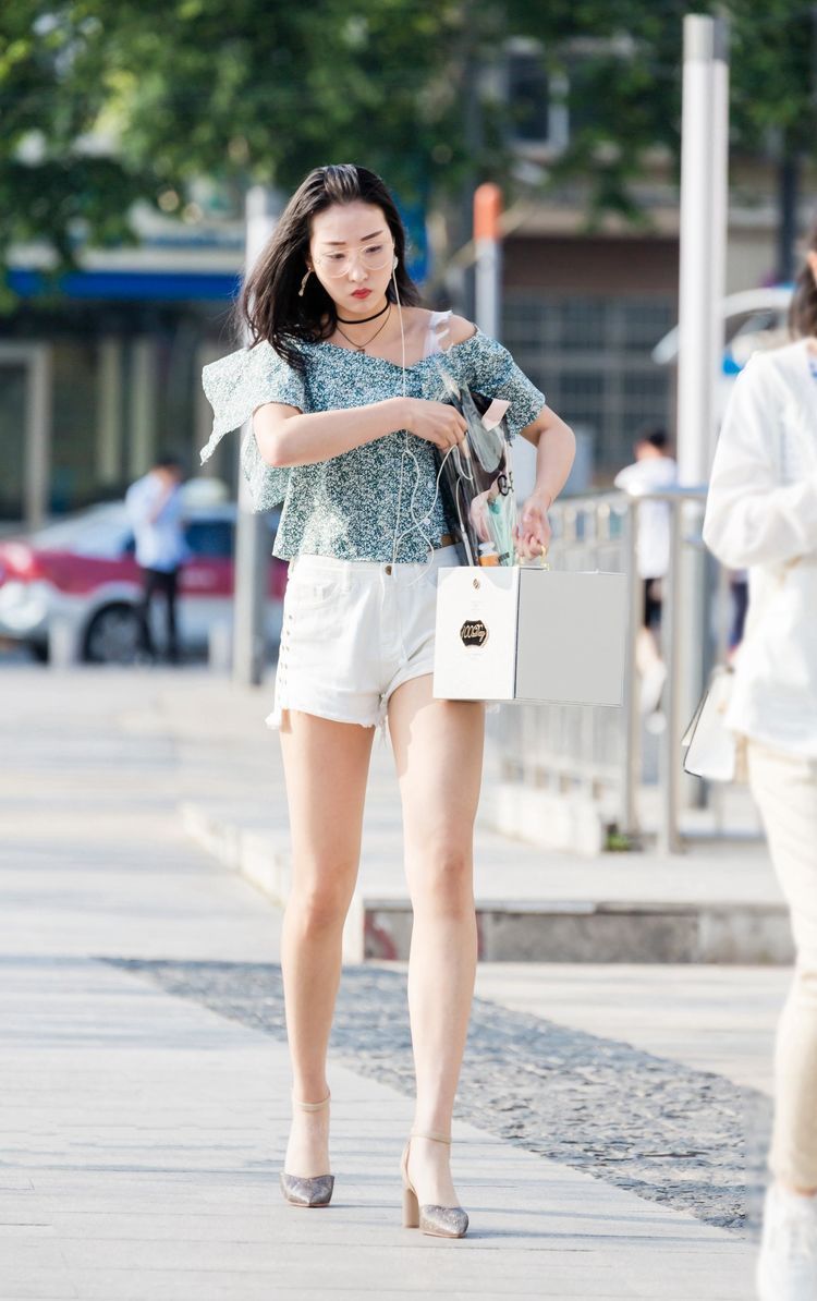 街拍:小姐姐牛仔短裤搭配露肩清凉的上衣,给人阳光甜美的感觉