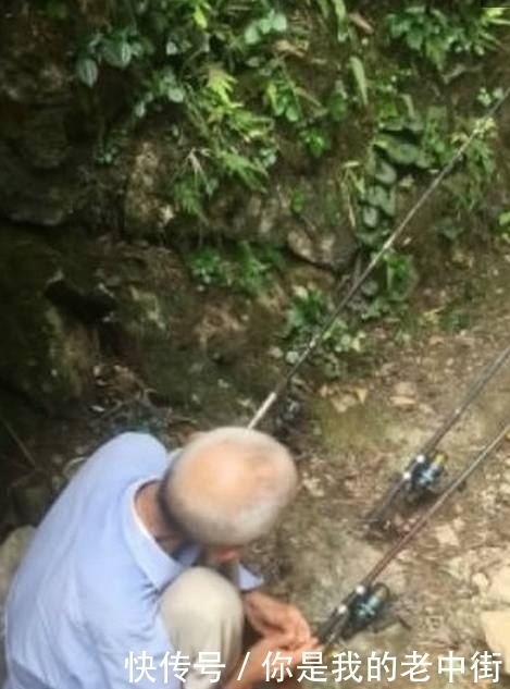 农民拿着钓鱼竿,在石头缝中钓鱼,网友:能钓到吗?