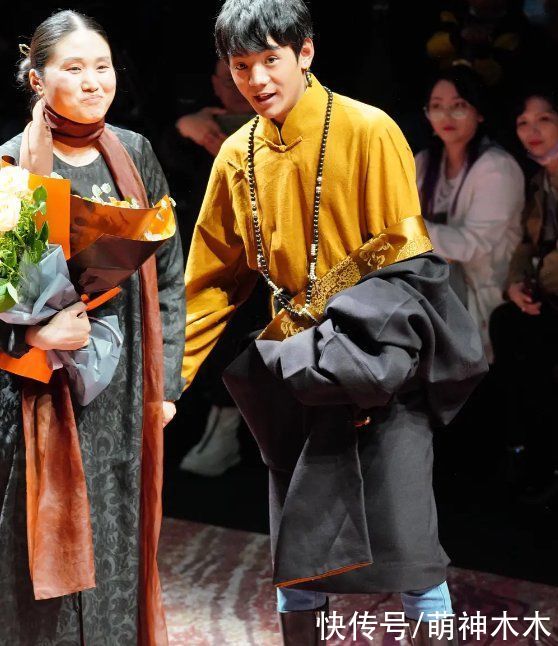 丁真首次亮相上海时装周，换上全套妆发造型看秀，为设计师献花