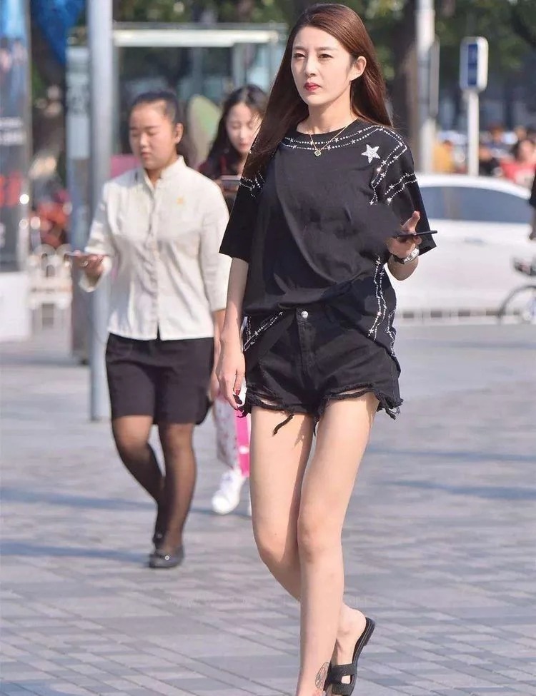 街拍:棕色卷发披肩的小美女,配戴一副黑色墨镜,显得气场十足