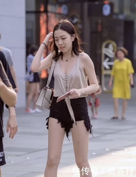 上半身穿着一件吊带衫,胸前的系带增添了设计感显得不再单调