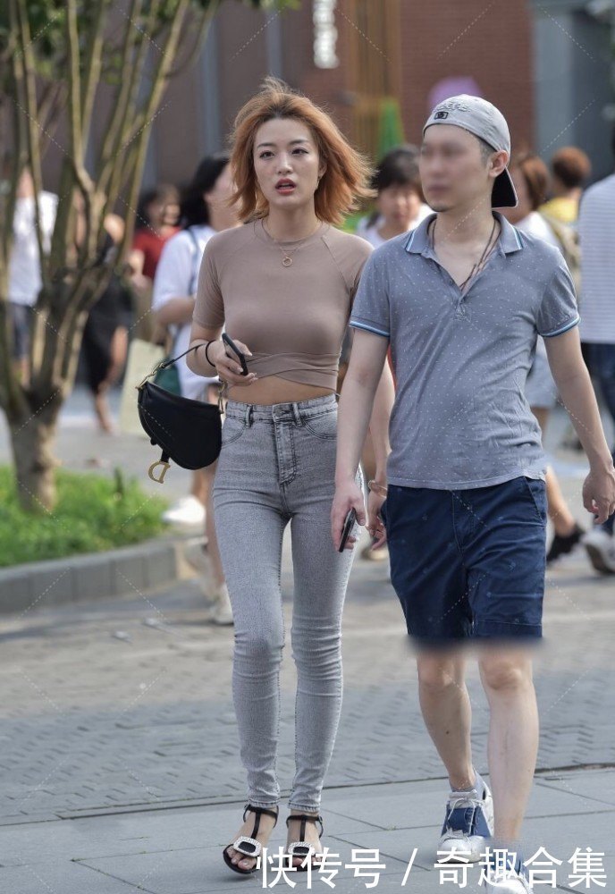 街拍紧身衣搭配灰色牛仔裤裹的很严实,衣摆设计展现精致小蛮腰