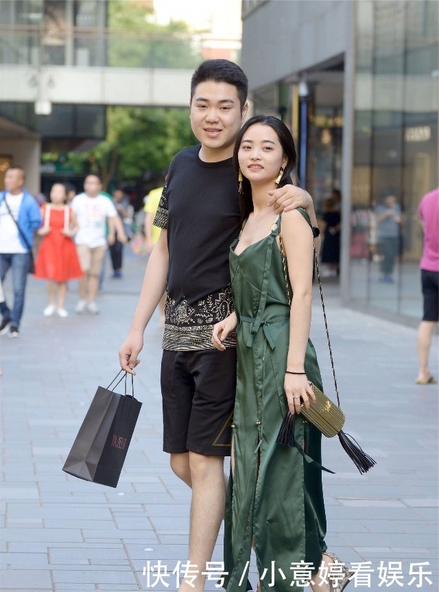 街拍:小姐姐穿墨绿色的开叉连衣裙,男朋友存托下显得大方又靓丽