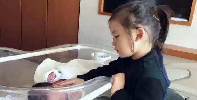 弟弟趁着姐姐看电视，站在姐姐旁偷吃鸡腿，姐姐一低头被萌到了